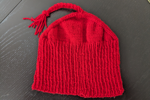 Knitted red cap with a pointy top